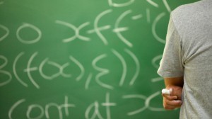 Student Working Out Math Equation on Blackboard